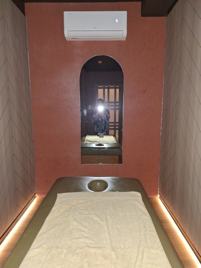 Warm-lit massage room with a heated table